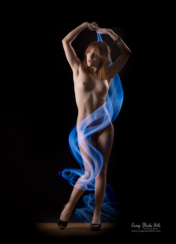 Nude female wrapped in blue smoke