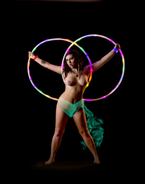 Nude female with lighted hula hoops and clothing created from smoke trails